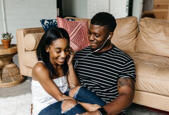 Happy couple sitting together while listening to a podcast