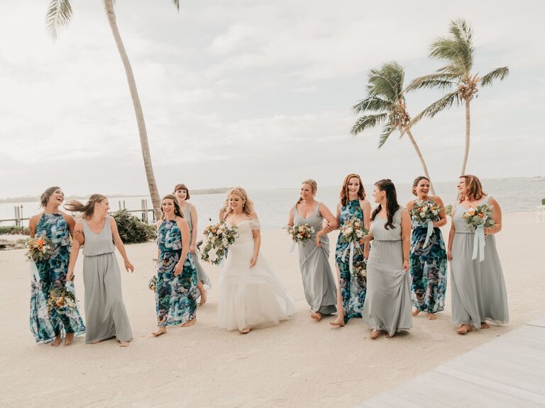 Bridesmaids wear mismatched beachy dresses. 