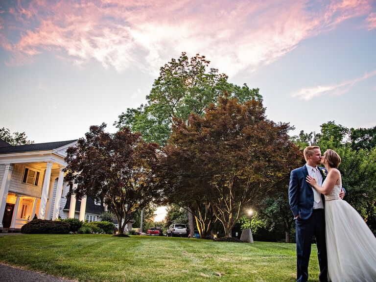 Couple kissing with the venue in the backdrop