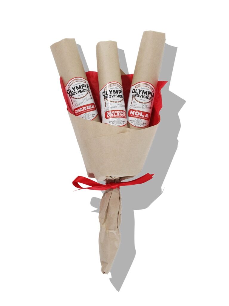 Bouquet of salami sticks wrapped in paper with a red bow thank-you gift