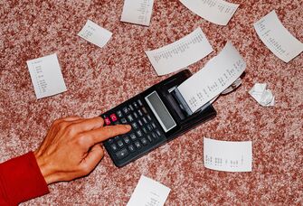 Man's hand using calculator to calculate registry completion discount