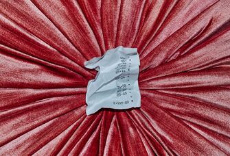 Crumpled receipt on pink velvet background