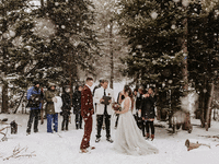 Couple having their wedding ceremony in the snow during mountain elopement.
