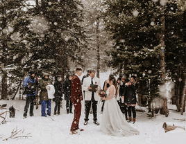 Couple having their wedding ceremony in the snow during mountain elopement.