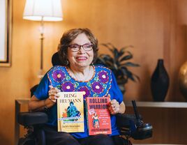 Author Judy Heumann holding her two books