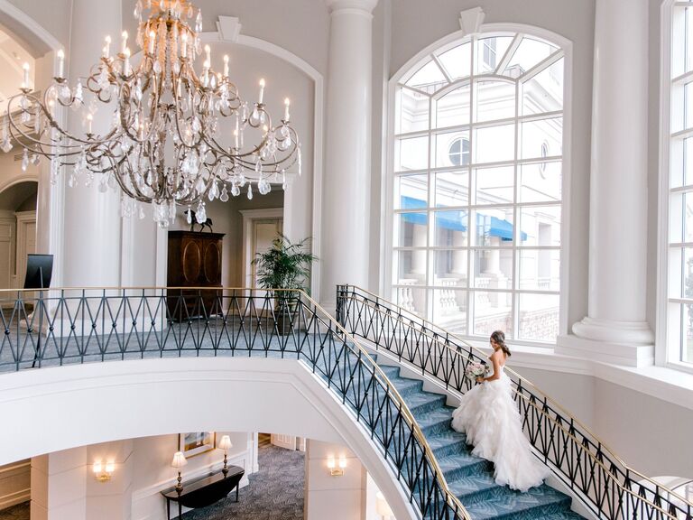 Bride walking up the grand staircase of the venue