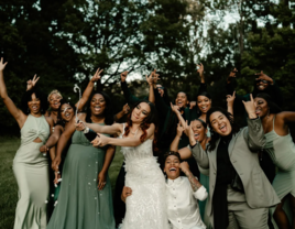 Bride popping champagne with bridesmaids on wedding day