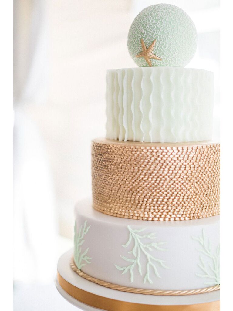 Large four-tier beach wedding cake with light blue and copper textured layers and round top