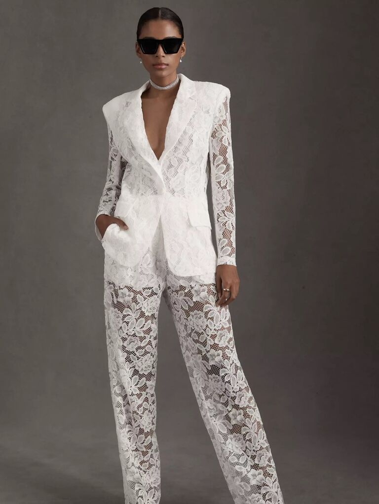 Model wears a white lace pantsuit. 