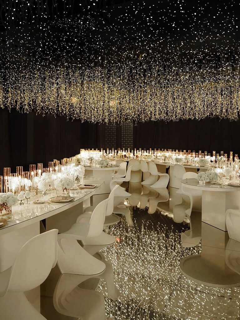 Modern wedding reception space with dark walls and fairy lights