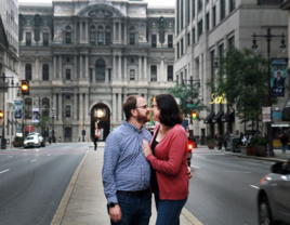 Couple smiling at each other and hugging in downtown Philadelphia, Pennsylvania