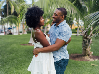 Couple huggin in front of palm trees, Miami engagement photo locations