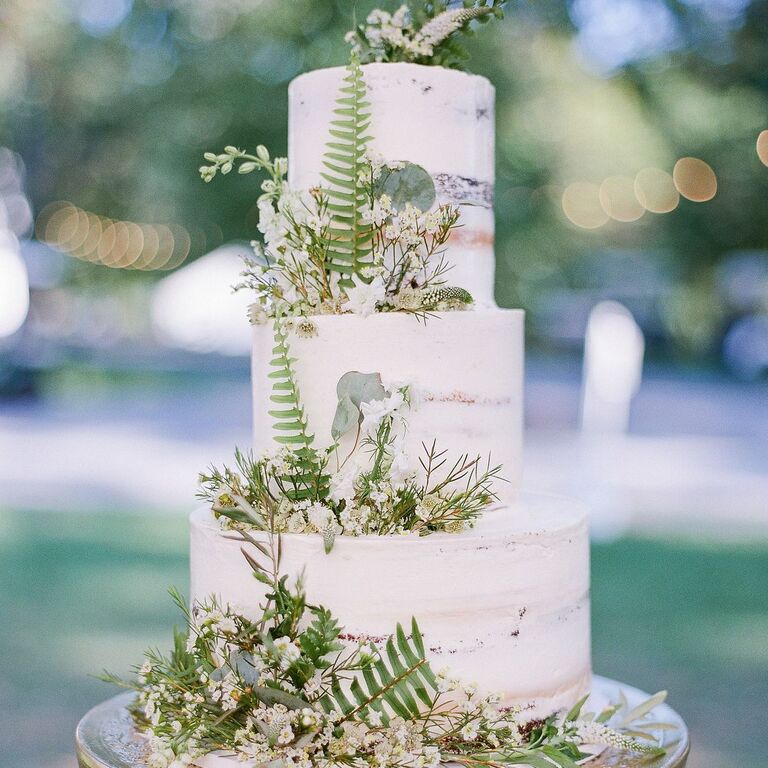 Semi-naked three-tier cake with fern and baby's breath decorations