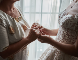 mother and daughter holding hands on wedding day