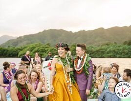 Newlywed couple on boat at wedding with guests