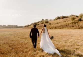 Couple holding hands in field in Nebraska, how to get married in Nebraska 