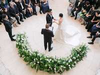 Wedding ceremony in the round with greenery arch