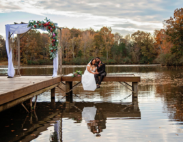 Bride and groom sitting on dock at The Carolyn Baldwin Lake Pavilion small wedding venue in Virginia