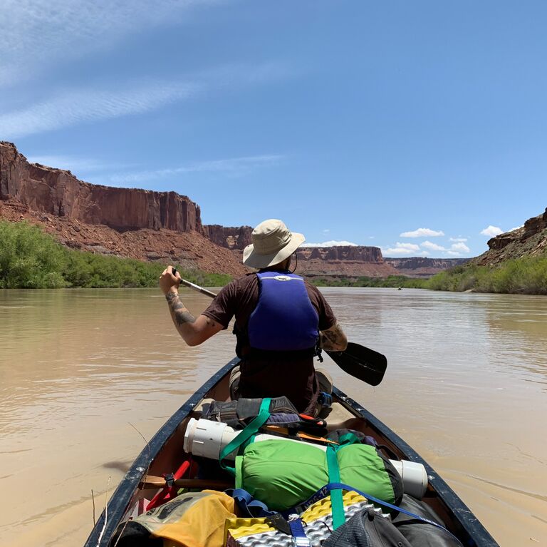 Juli teaches John how to canoe. 