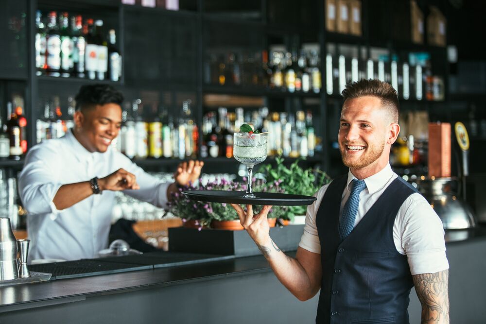 attractive drink server with vest and tattoo