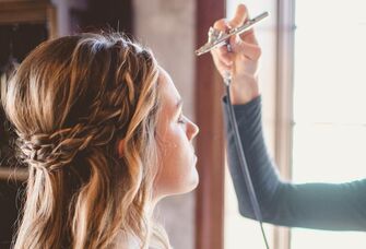 Woman getting airbrush makeup applied