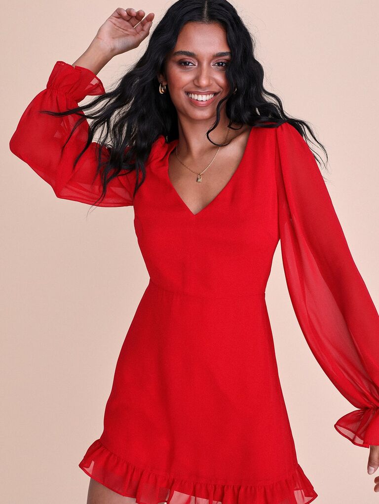 Model wears a red long-sleeved mini dress. 