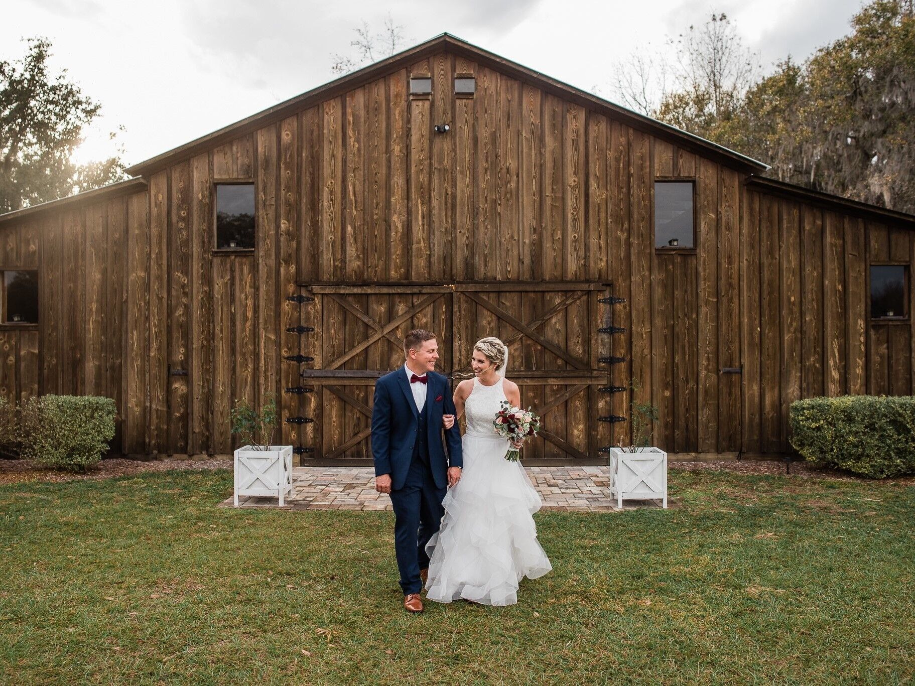 Couple smiling for a portrait outside the barn wedding venue