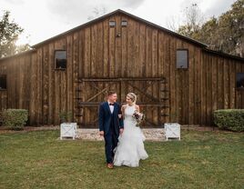 Couple smiling for a portrait outside the barn wedding venue