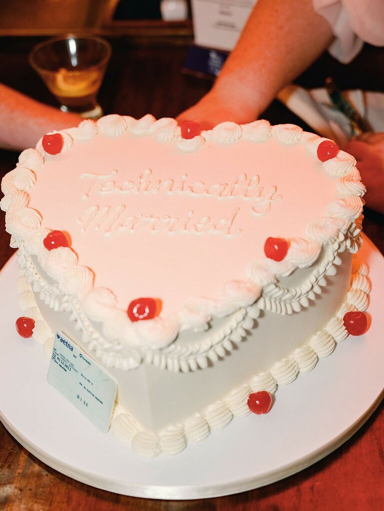 retro heart shaped wedding cake decorated with white piping and red cherries