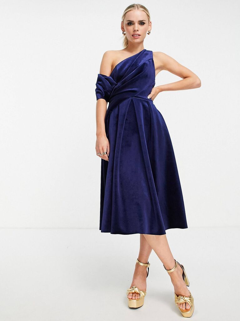 Model wears a blue velvet midi dress. 