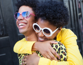 A young woman hugging her boyfriend from behind