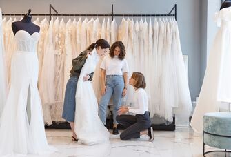 Bride looking at wedding dress with bridal stylist