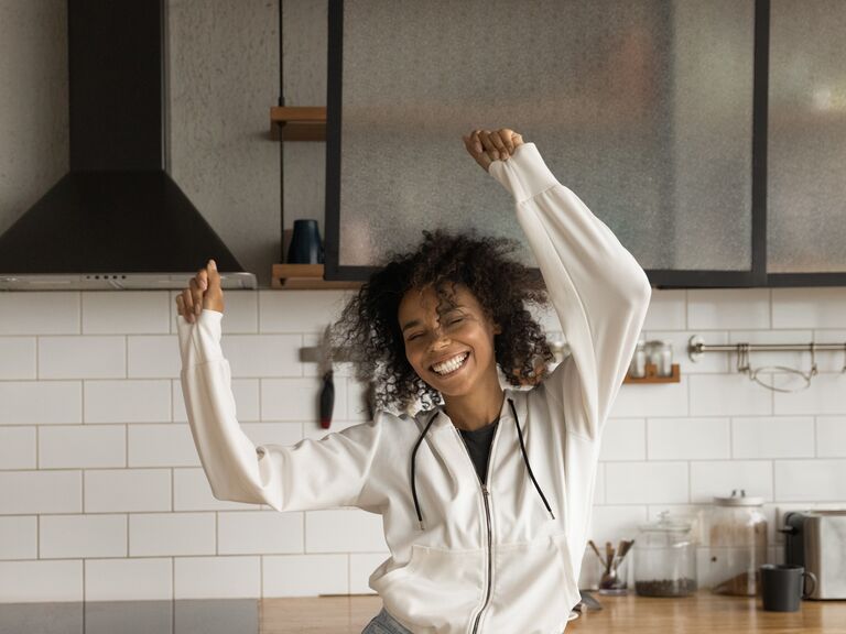 Independent woman dancing in her kitchen.
