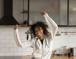 Independent woman dancing in her kitchen.