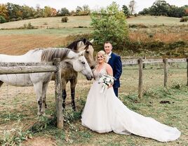 Happy couple standing beside two horses at Events at 4T Arena