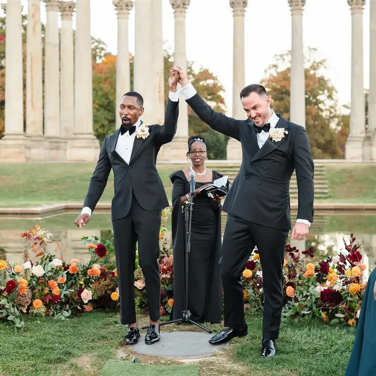 Newlywed grooms at altar surrounded by autumnal flowers, fall wedding photos