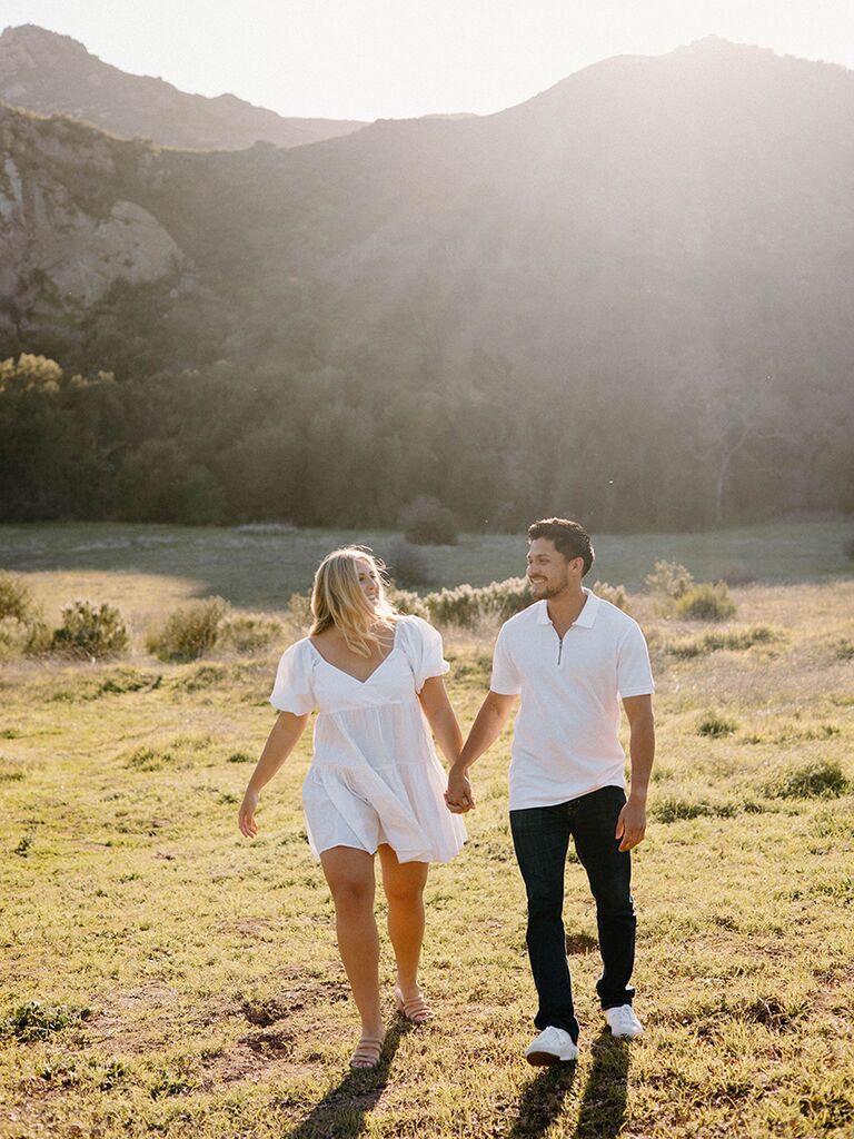 Couple wearing white and walking in the countryside
