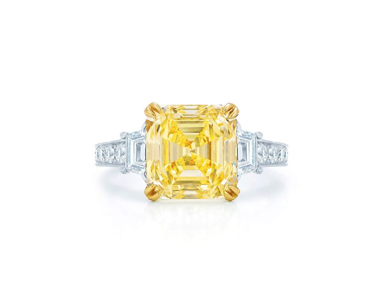 kwiat asscher cut engagement ring with yellow diamond center stone yellow gold claw prongs baguette diamond sides and round diamond encrusted white gold band with milgrain detailing