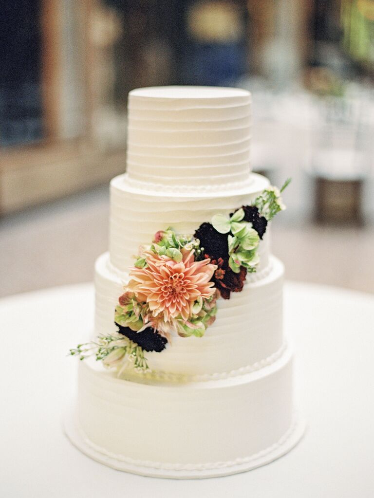 four tier textured buttercream wedding cake with pink dahlia and burgundy flowers