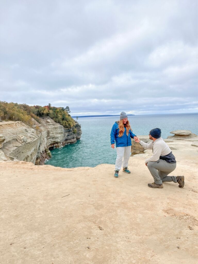 Evan proposed to Demiree in Munising, MI. They went up north with their friends, Kaellin, Donovan and Abby for what Demiree thought was a hiking trip. Evan popped the question after hiking TEN miles on this lake overview! Demiree had no idea and was even pulling Evan up when he got down on his knee because she thought he was joking. Let the wedding planning BEGIN!