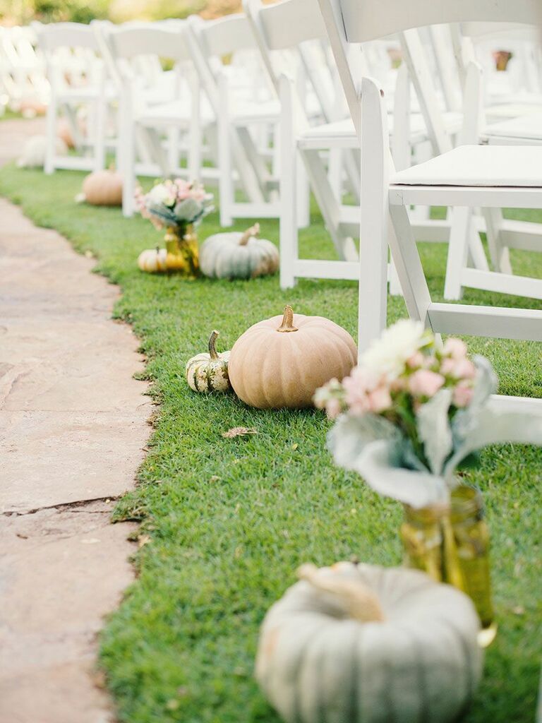 outdoor wedding ceremony venue with orange and green pumpkin aisle markers 