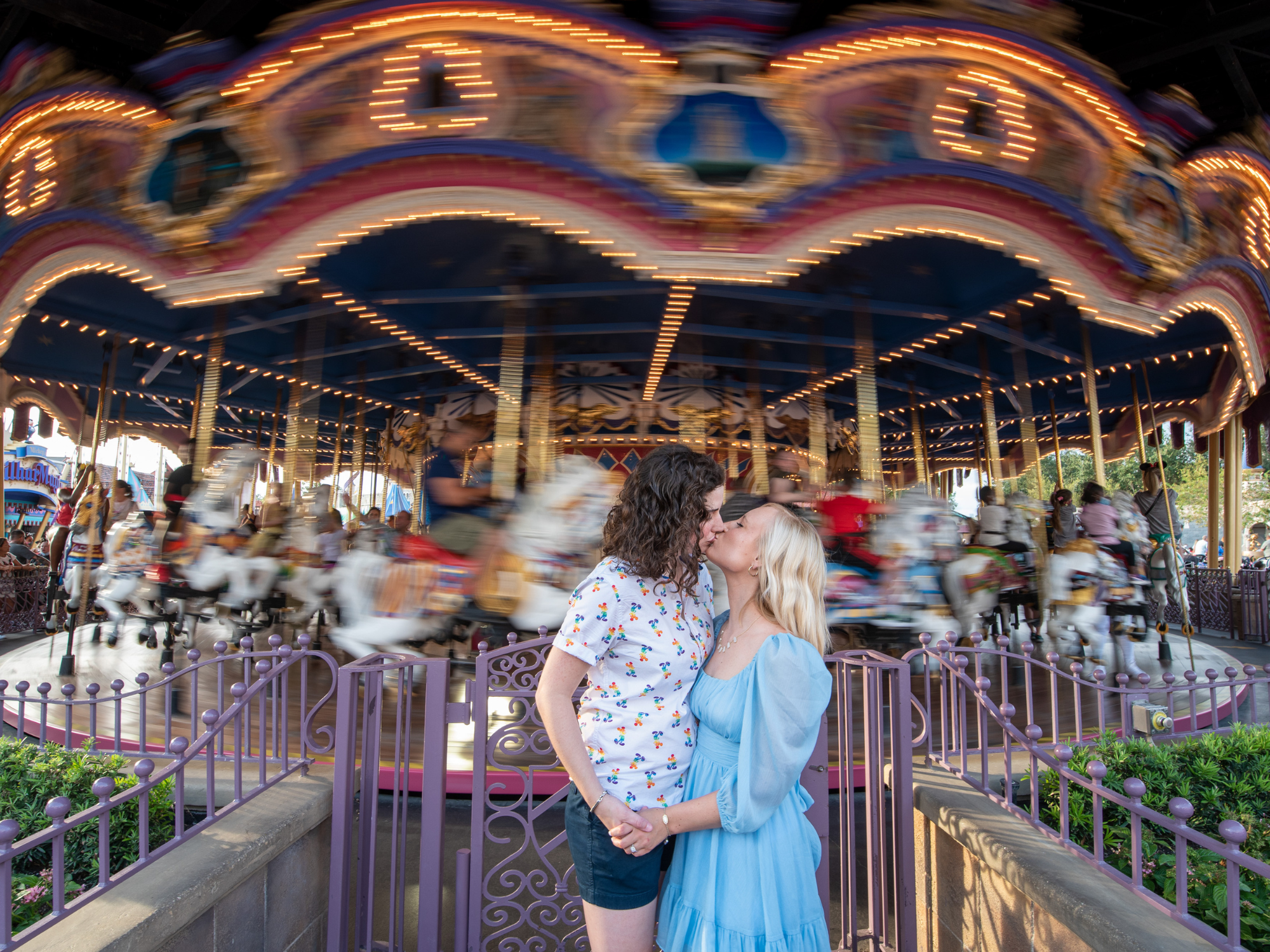 Cute Kiss Engagement Photo in Front of Prince Charming Regal Carrousel Disney Engagement Photo Inspiration
