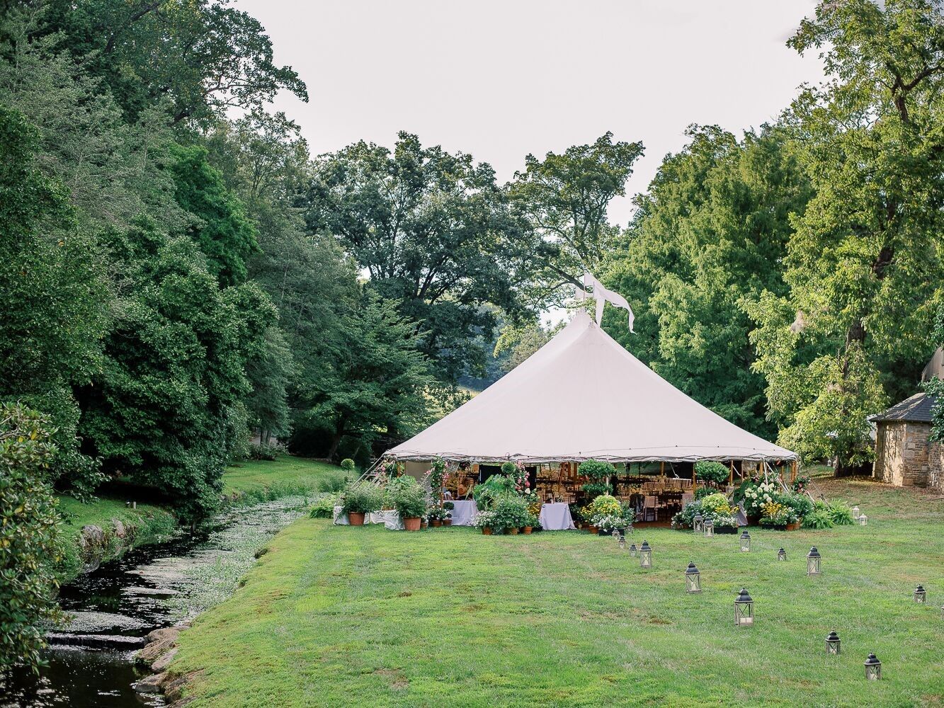 Outdoor tipi on estate grounds beside a flowing stream