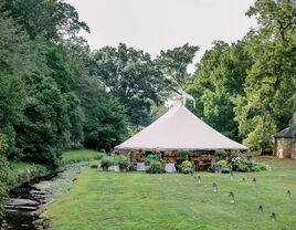 Outdoor tipi on estate grounds beside a flowing stream