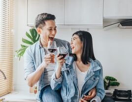 couple smiling holding wine glasses