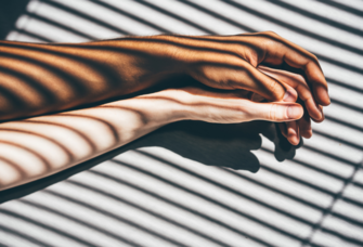 Couple holding hands in shadow of window shades