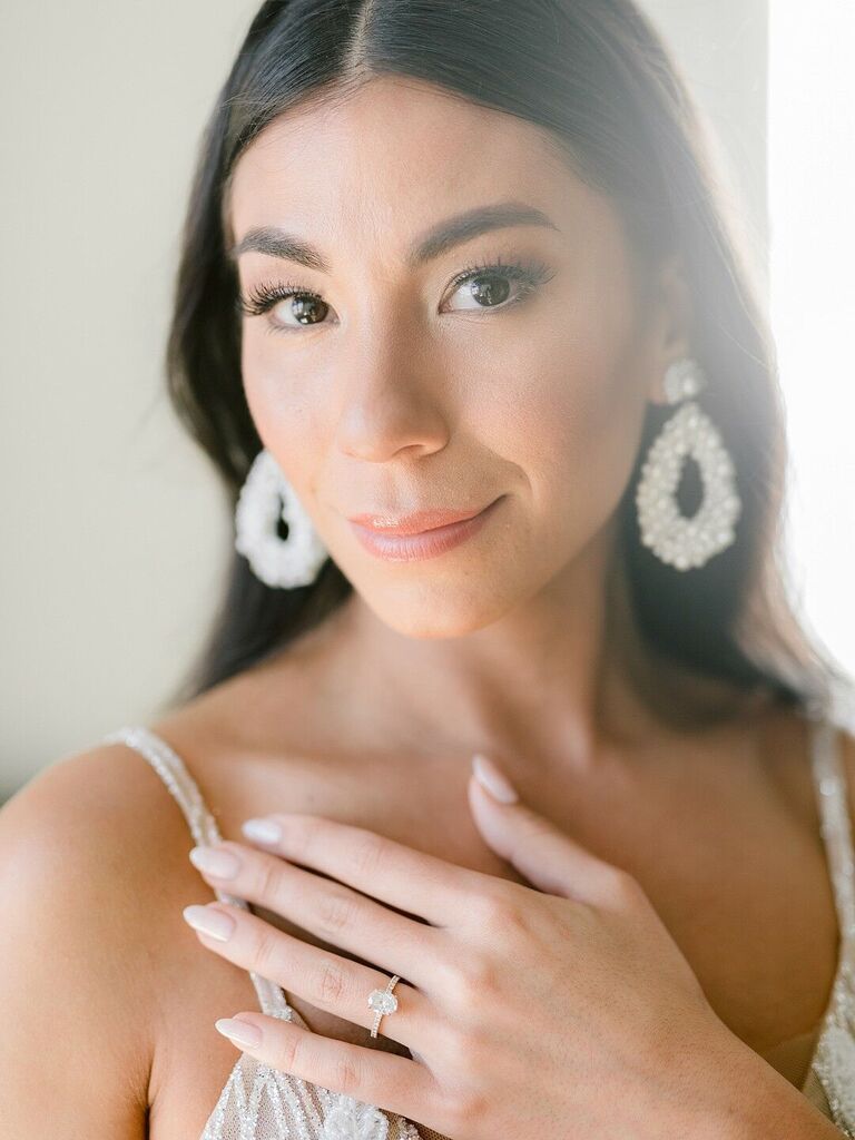 brunette bride with natural makeup, pearl drop earrings and nude oval shaped nails