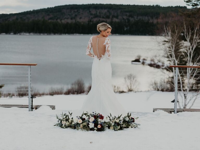 Woman showing the back of her wedding dress in a snowy landscape