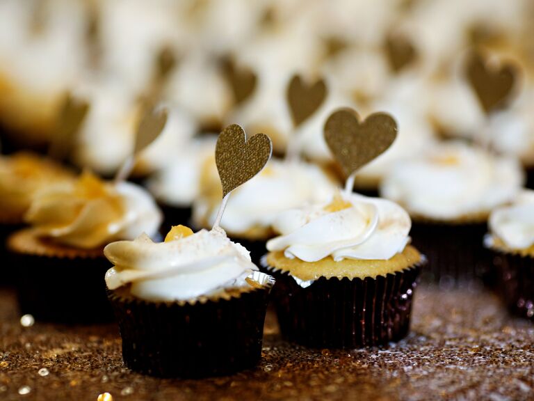 vanilla cupcakes with gold glitter heart-shaped toothpicks on gold sequin tablecloth