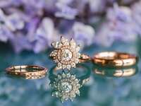 rose gold engagement ring with floral halo and wedding bands